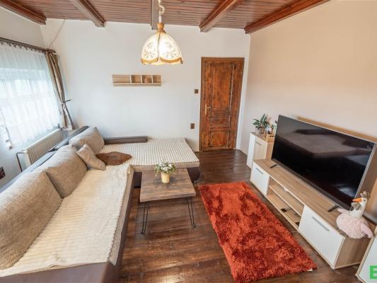 obývací pokoj s trámový strop, strop dřeva, televize, a dřevěná podlaha